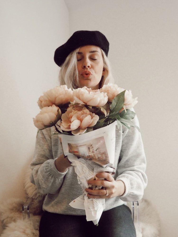 girl in beret holding flowers